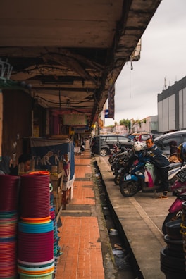 A vibrant street scene in Cartagena with motorcycles lined up outside a bustling shop.