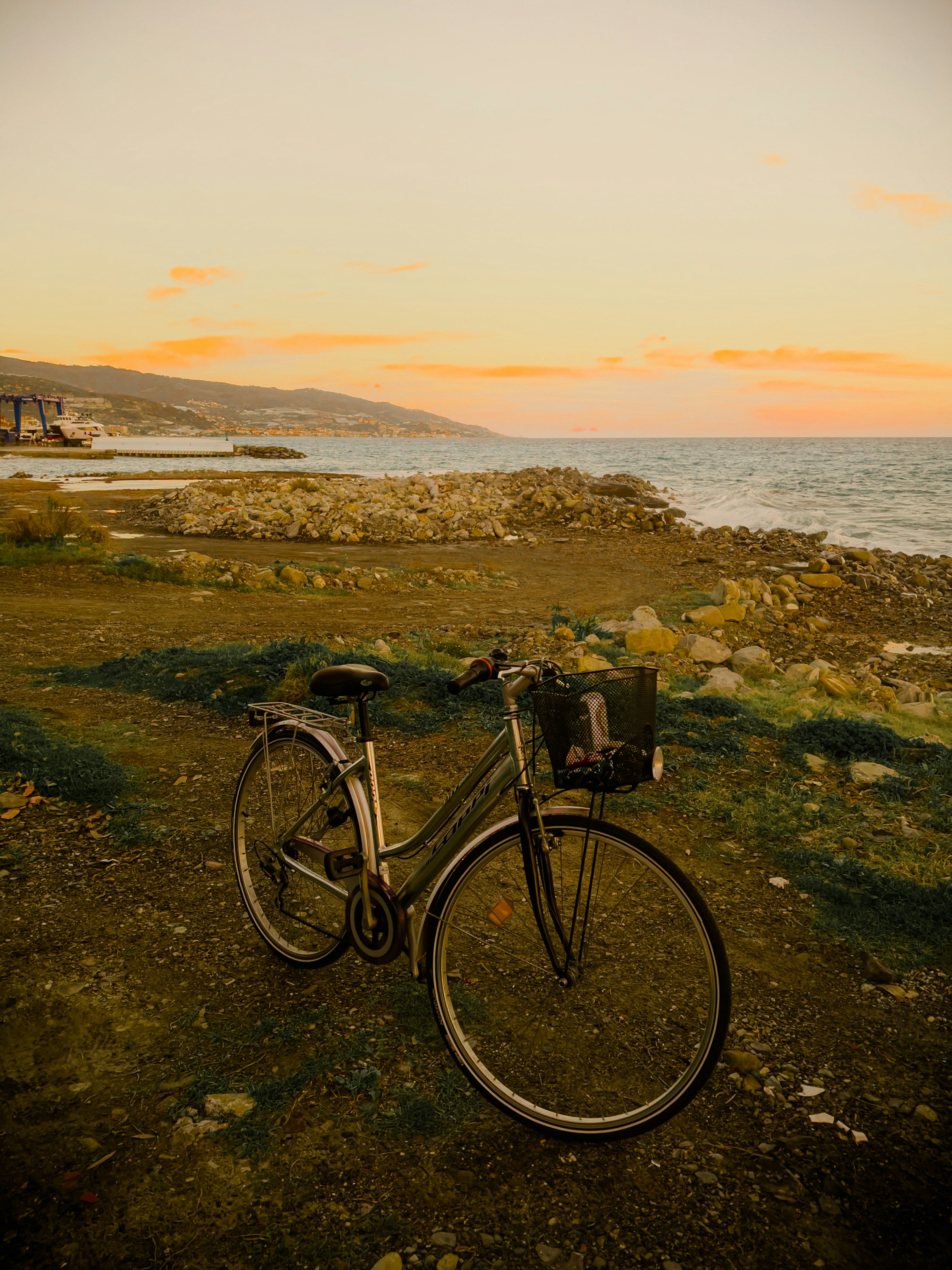 a bicycle parked on a rocky beach
