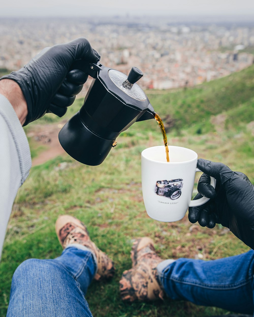 a person wearing a glove and holding a cup of coffee