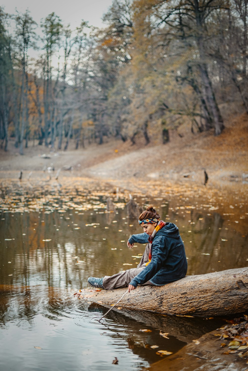 Ein Mann sitzt auf einem Baumstamm in einem Fluss
