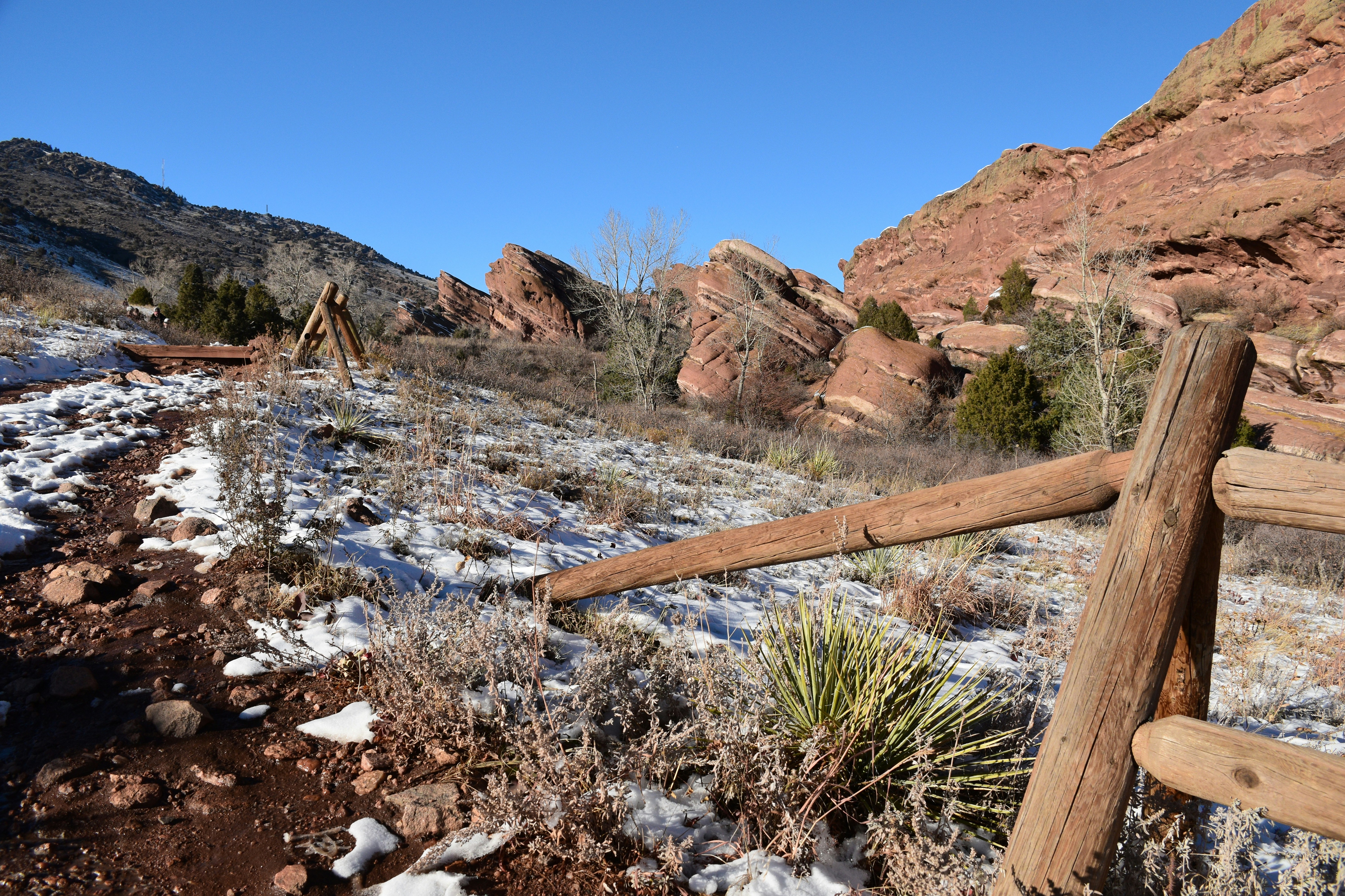 a wooden fence in a rocky area