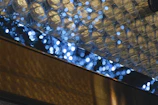 Abstract golden light reflections over matte black textured surface.
