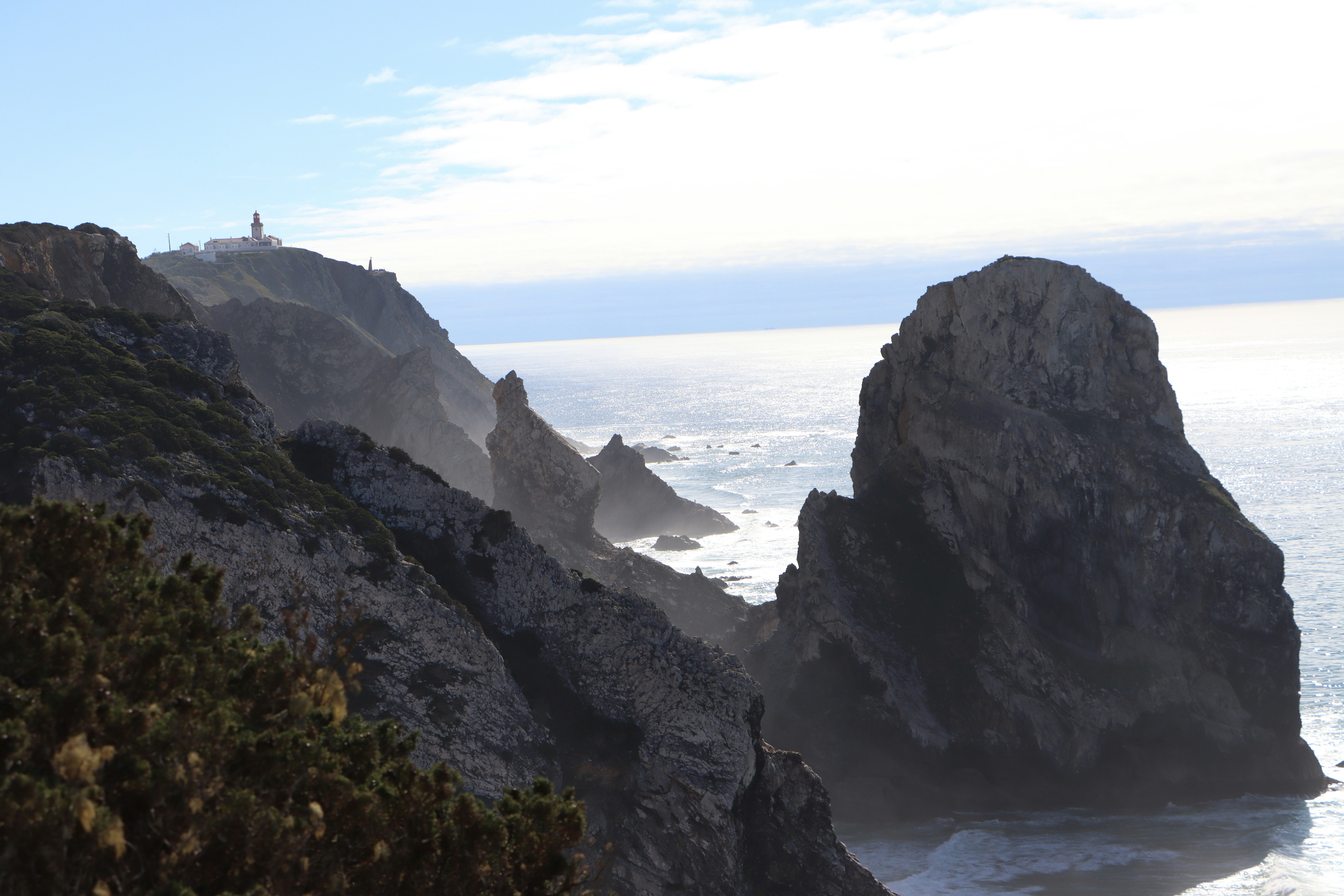 a rocky cliff with a lighthouse on it