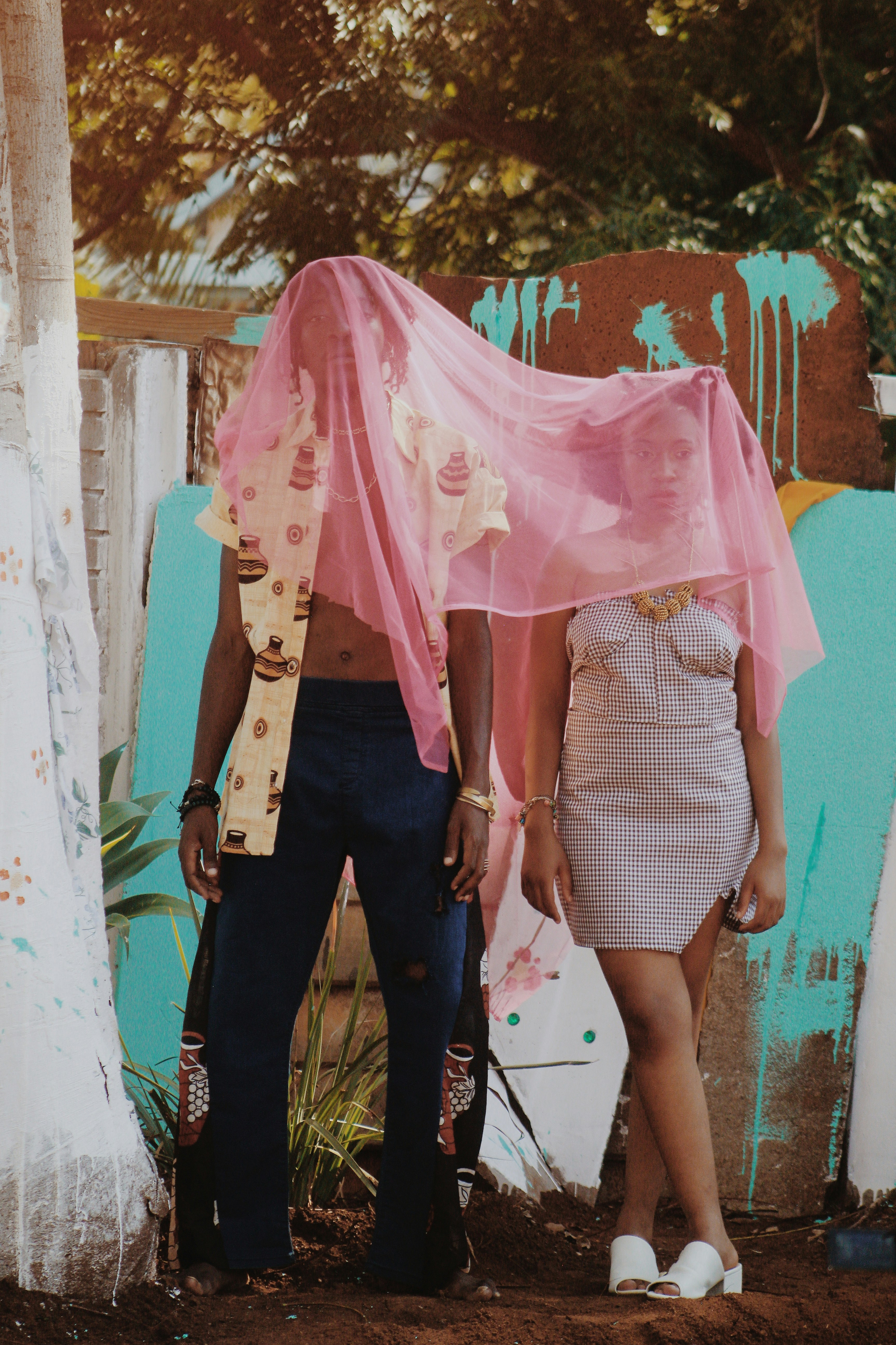 a man and woman standing under a colorful umbrella