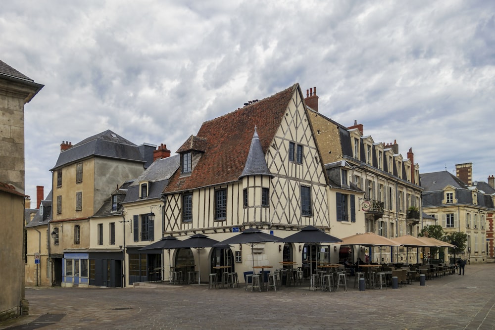 un groupe de bâtiments avec des tables et des parasols à l’avant