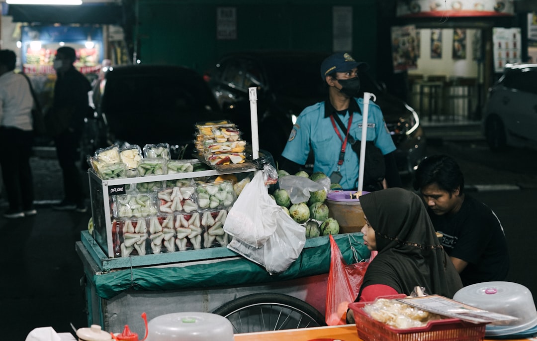 a group of people at a street market, Tropical fruit seller