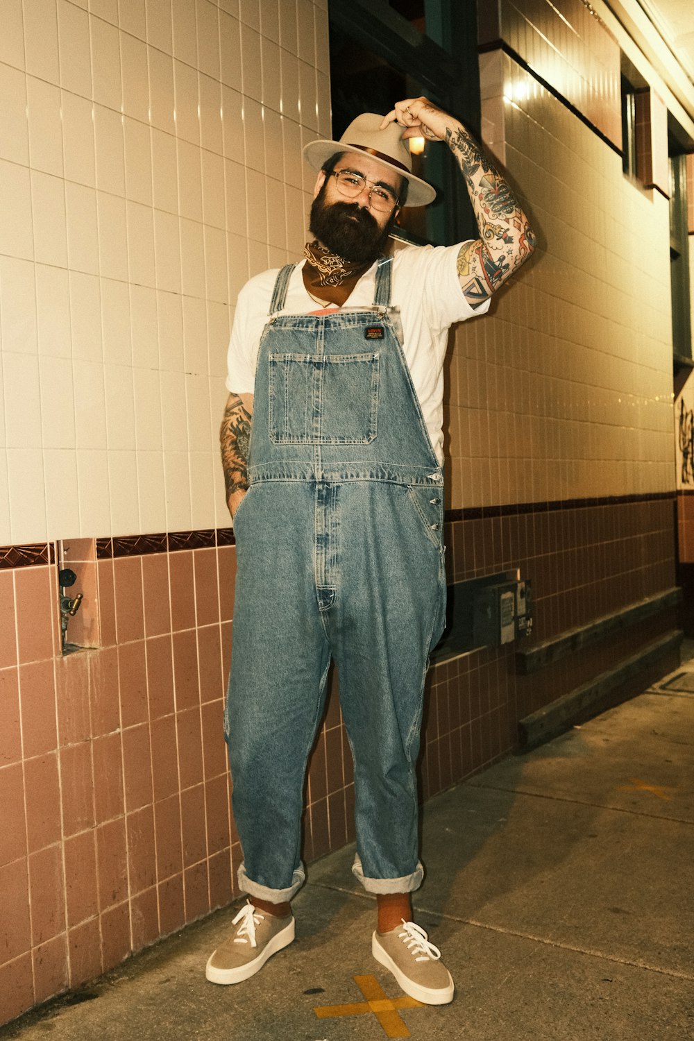 a man with a beard and hat holding a beer bottle