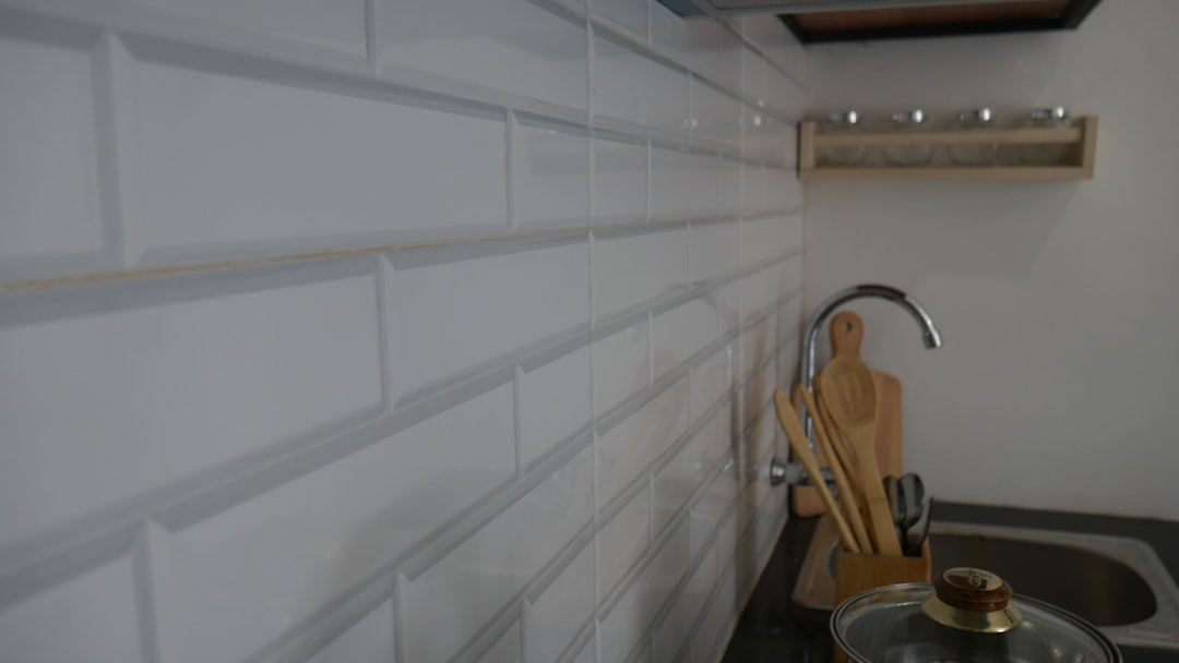 a kitchen with white tiles,