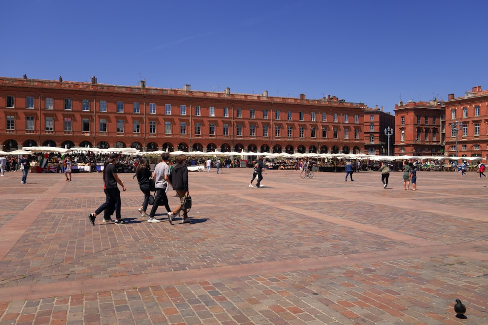 a group of people walking in a courtyard with Plaza Mayor, Madrid in the background