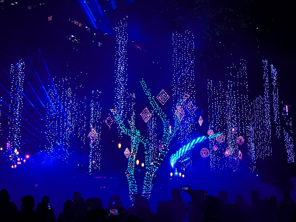 a crowd of people in front of a stage with lights