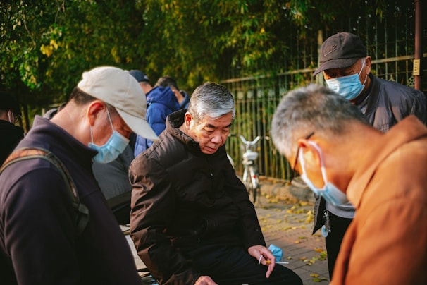 Elderly people smiling and engaging in a group activity outdoors.