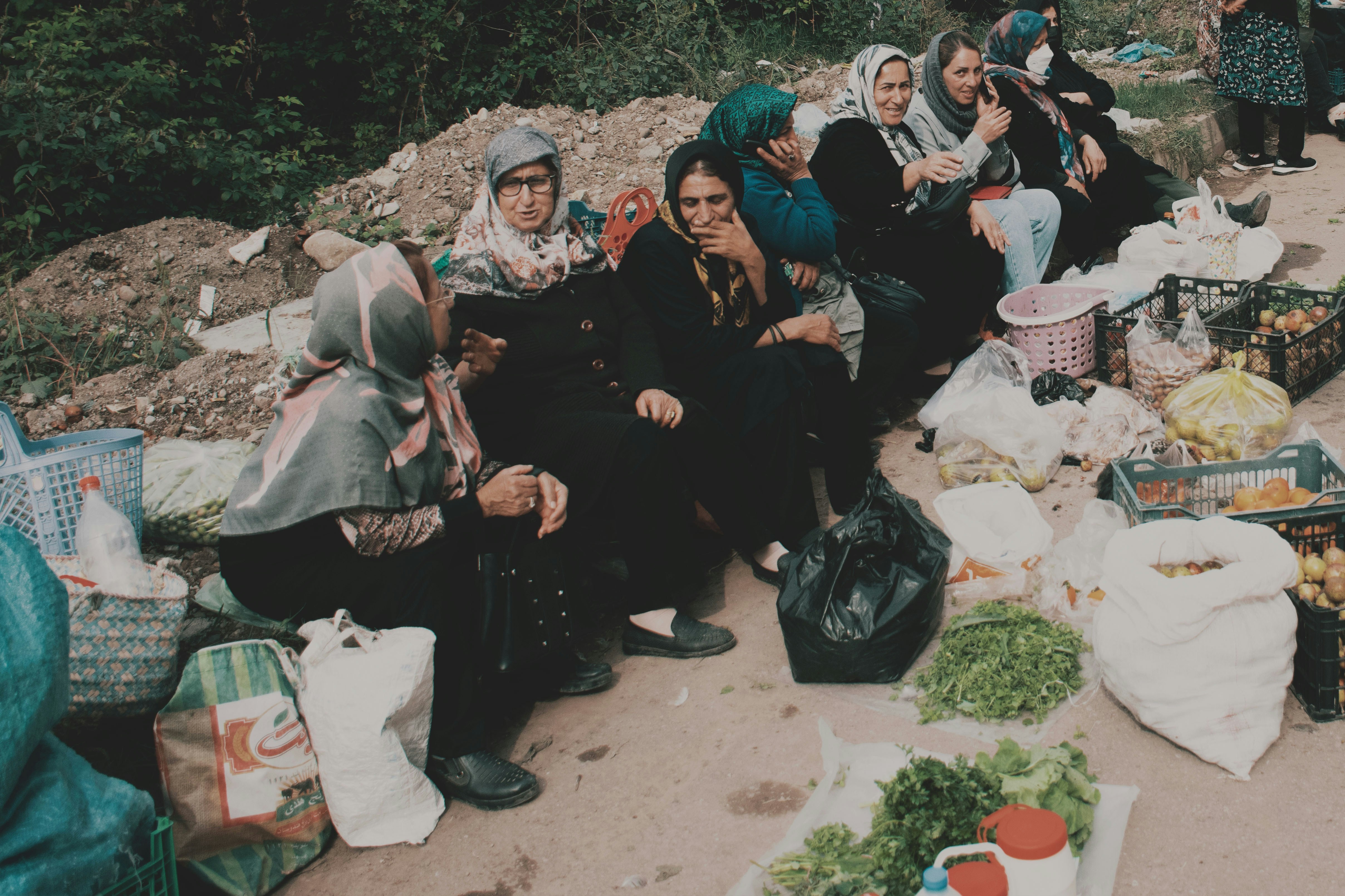 Women gathered at an outdoor market with produce