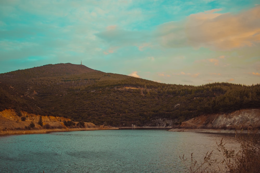 a body of water with hills in the back