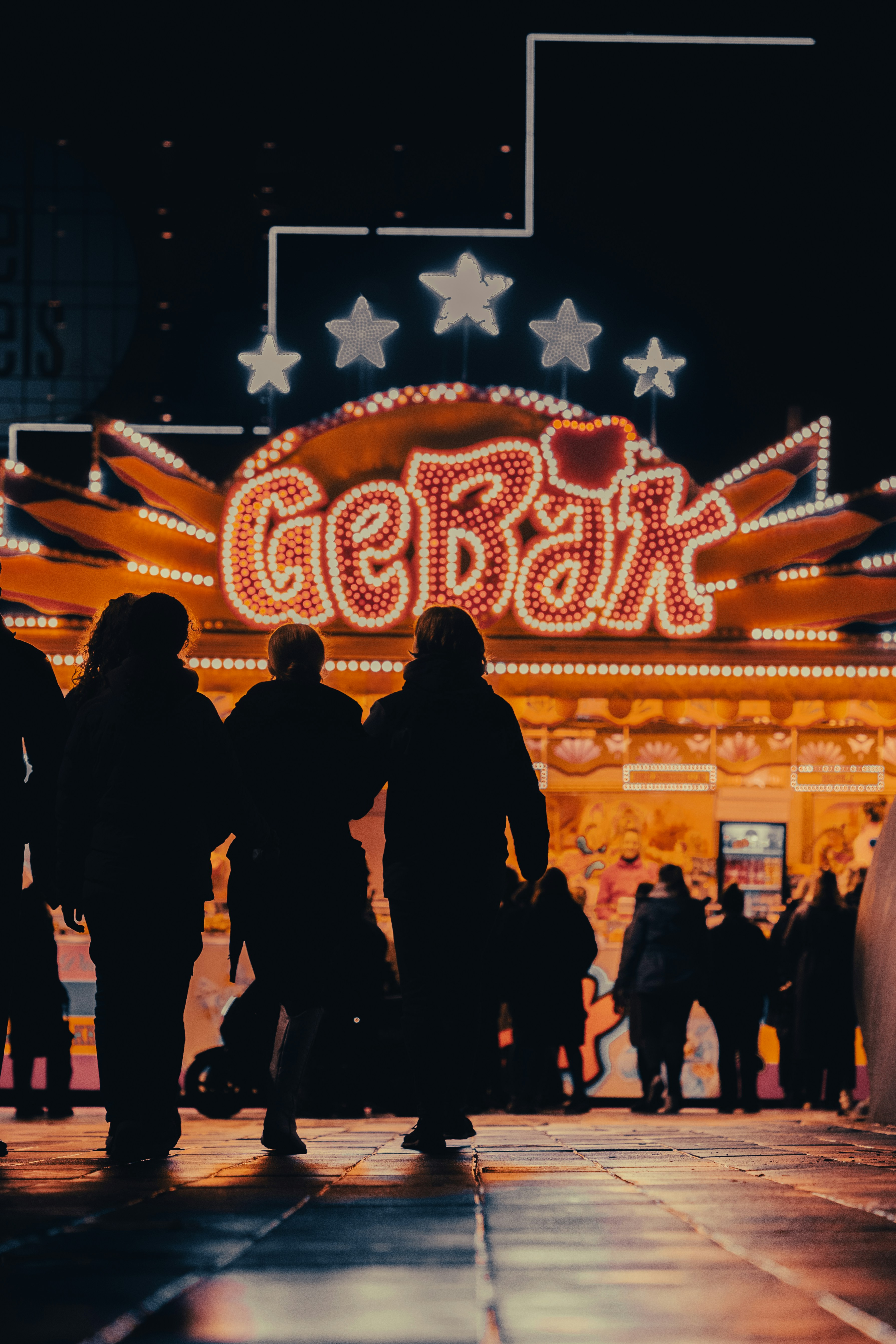 A group of people standing in front of a lighted sign photo – Free ...