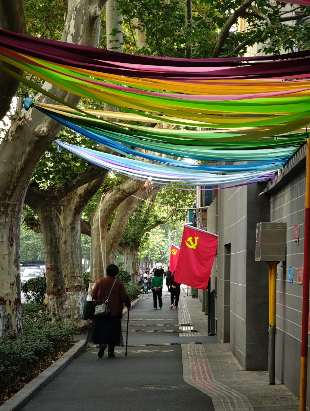 a person walking down a sidewalk under a colorful umbrella