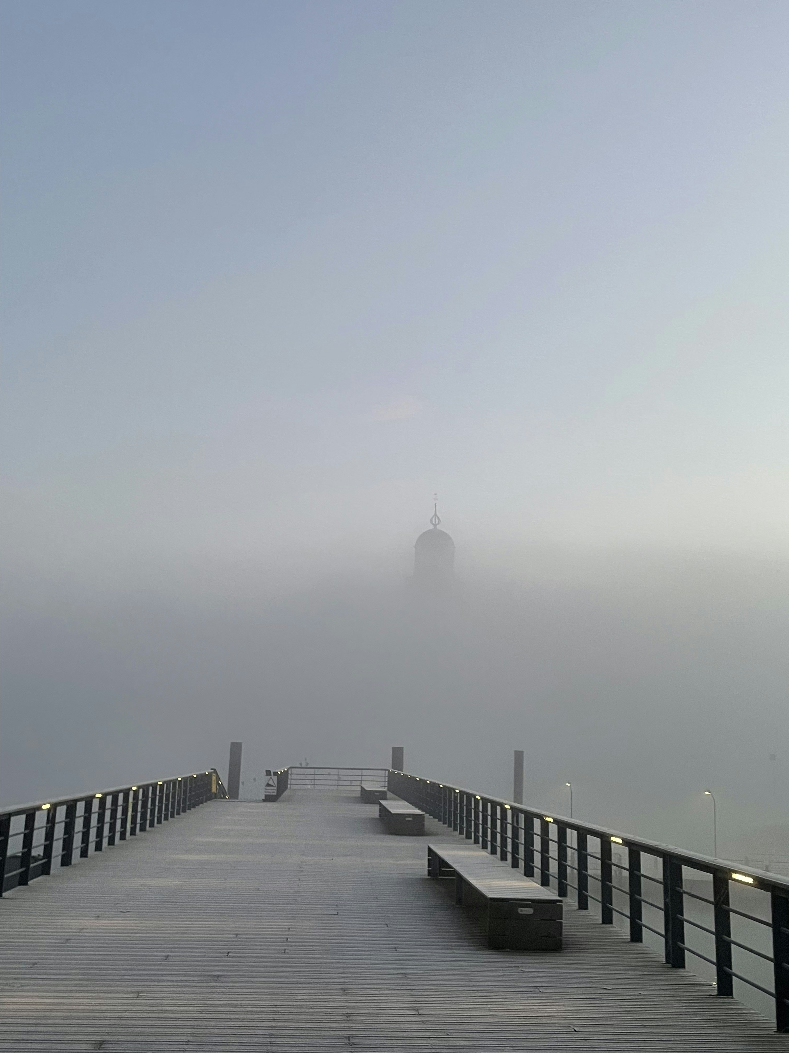a pier with a tower in the distance