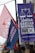 Colorful political banners and flags are displayed in an outdoor setting, featuring campaign slogans and symbols.