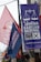 Colorful political banners and flags are displayed in an outdoor setting, featuring campaign slogans and symbols.