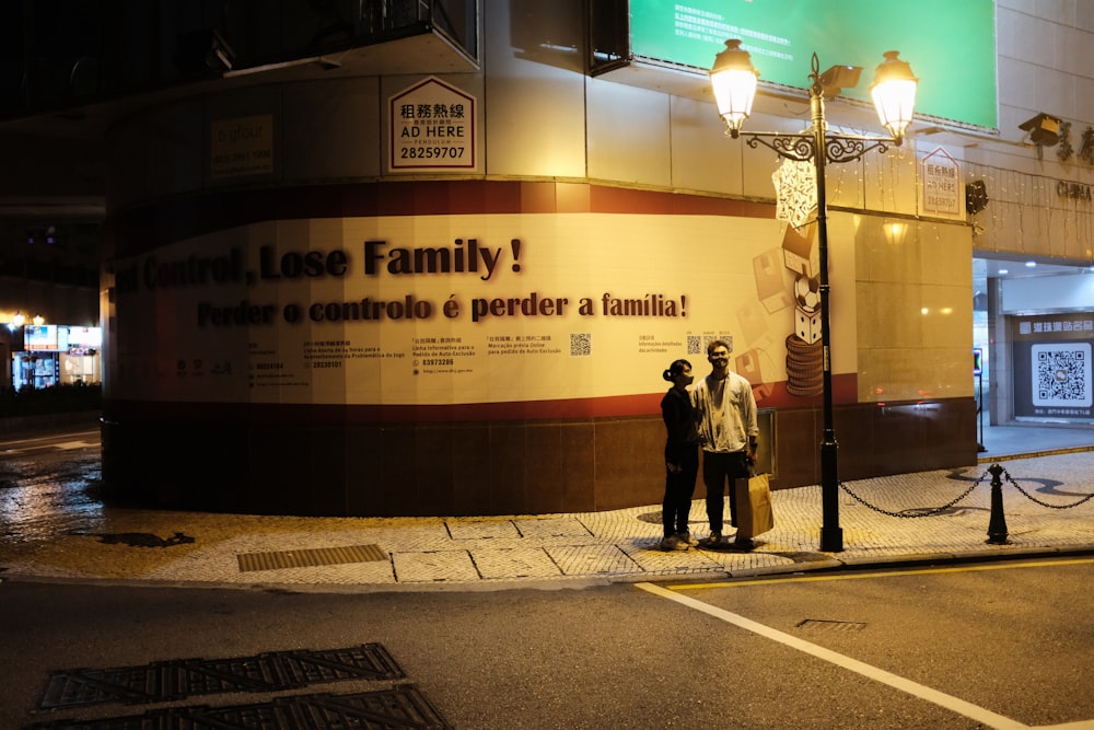 a couple of people standing in front of a sign