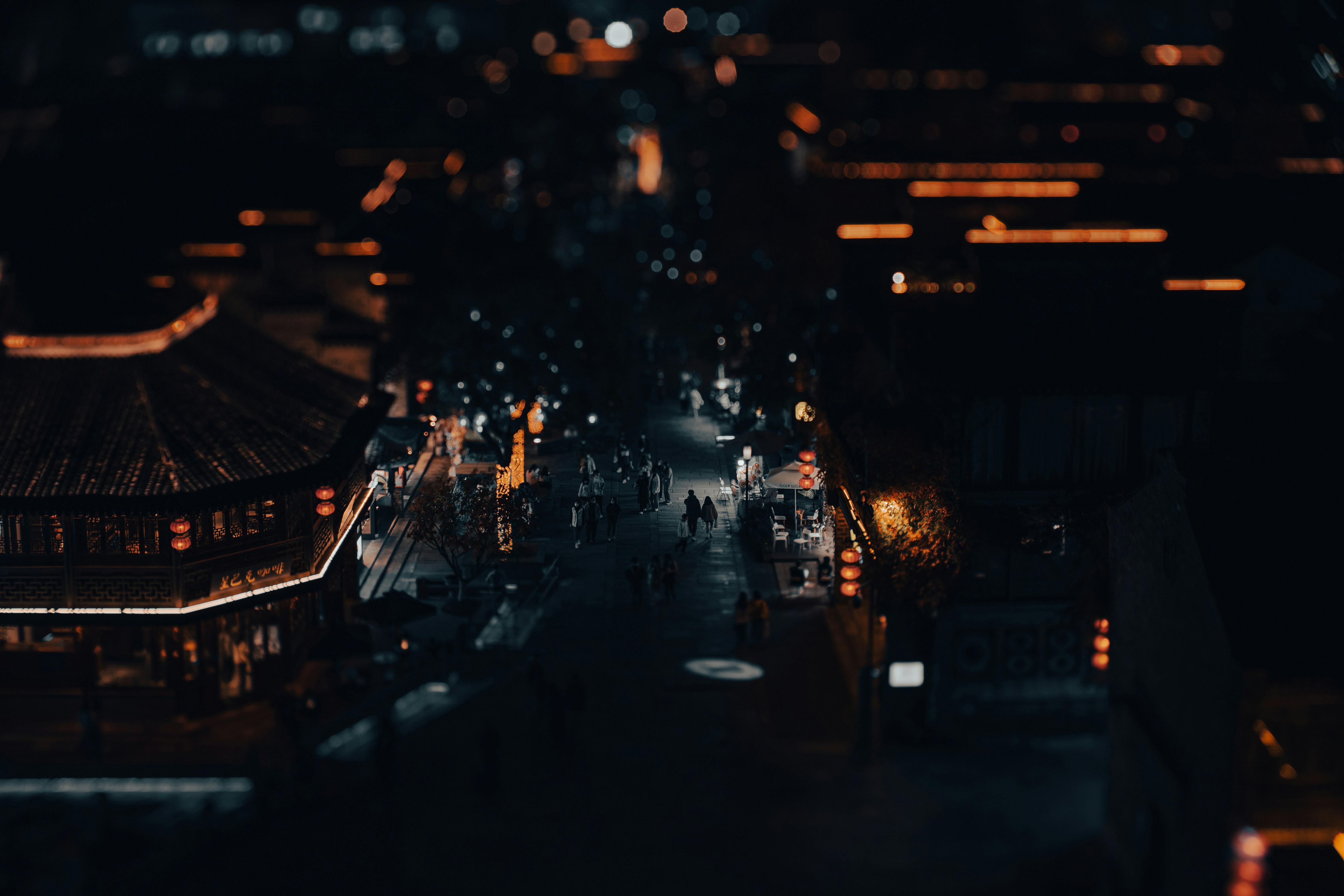 a group of people walking around a building with lights