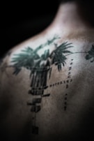 Bold tribal tattoo design on upper back with sharp lines.