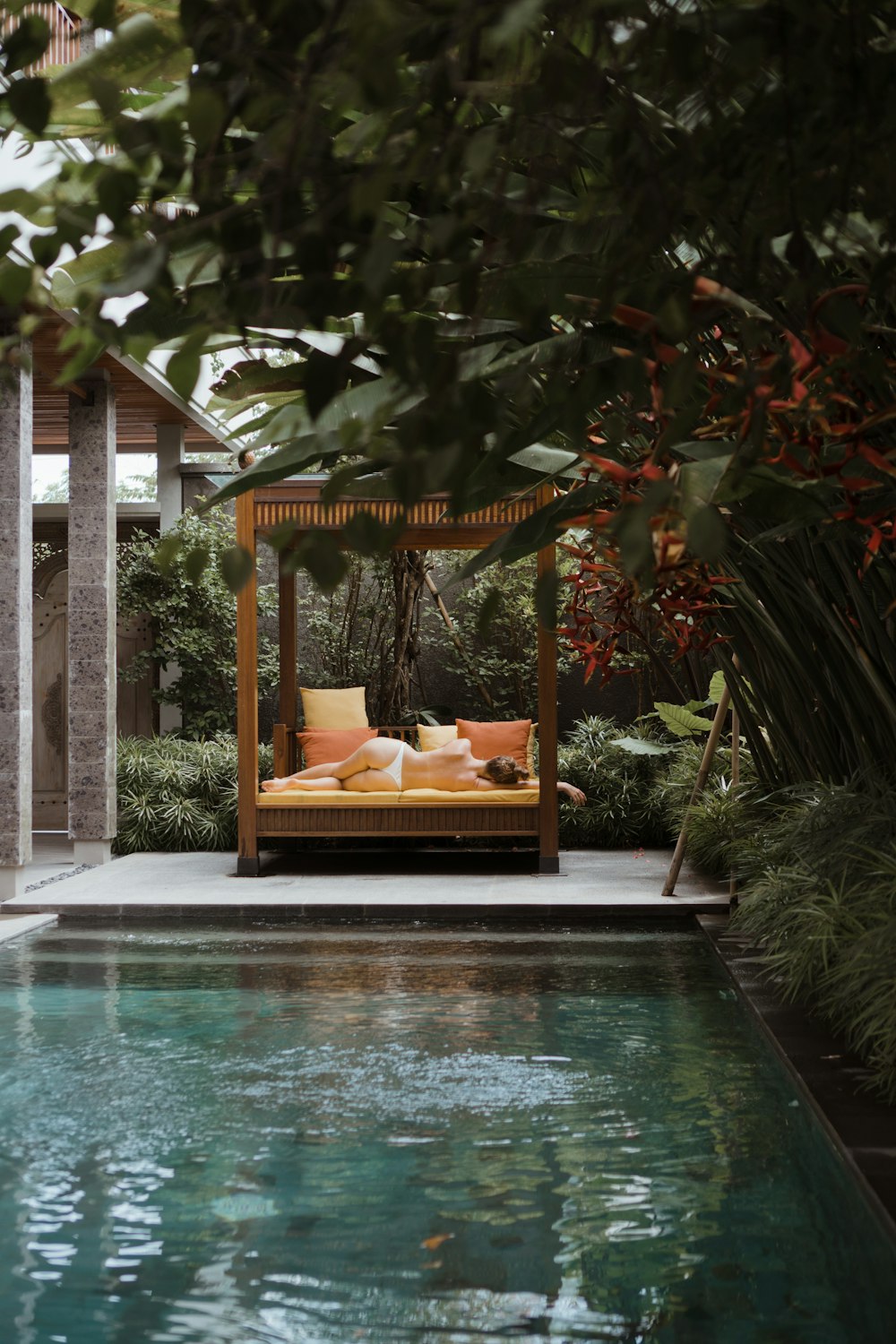 a pool with a lounge chair and a sign above it