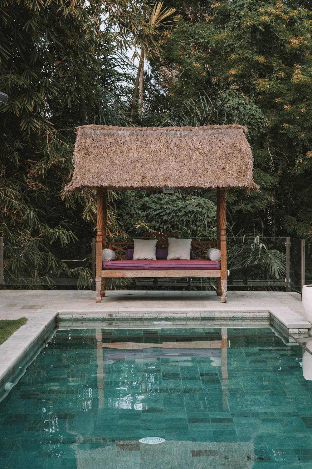 a chair and umbrella by a pool