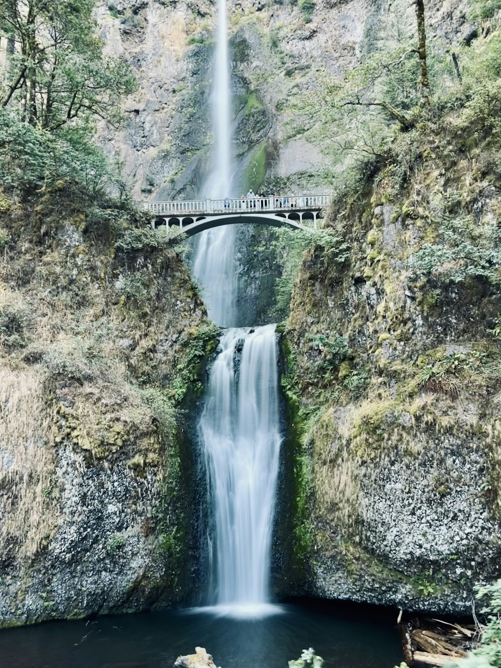 a large waterfall with a bridge over it