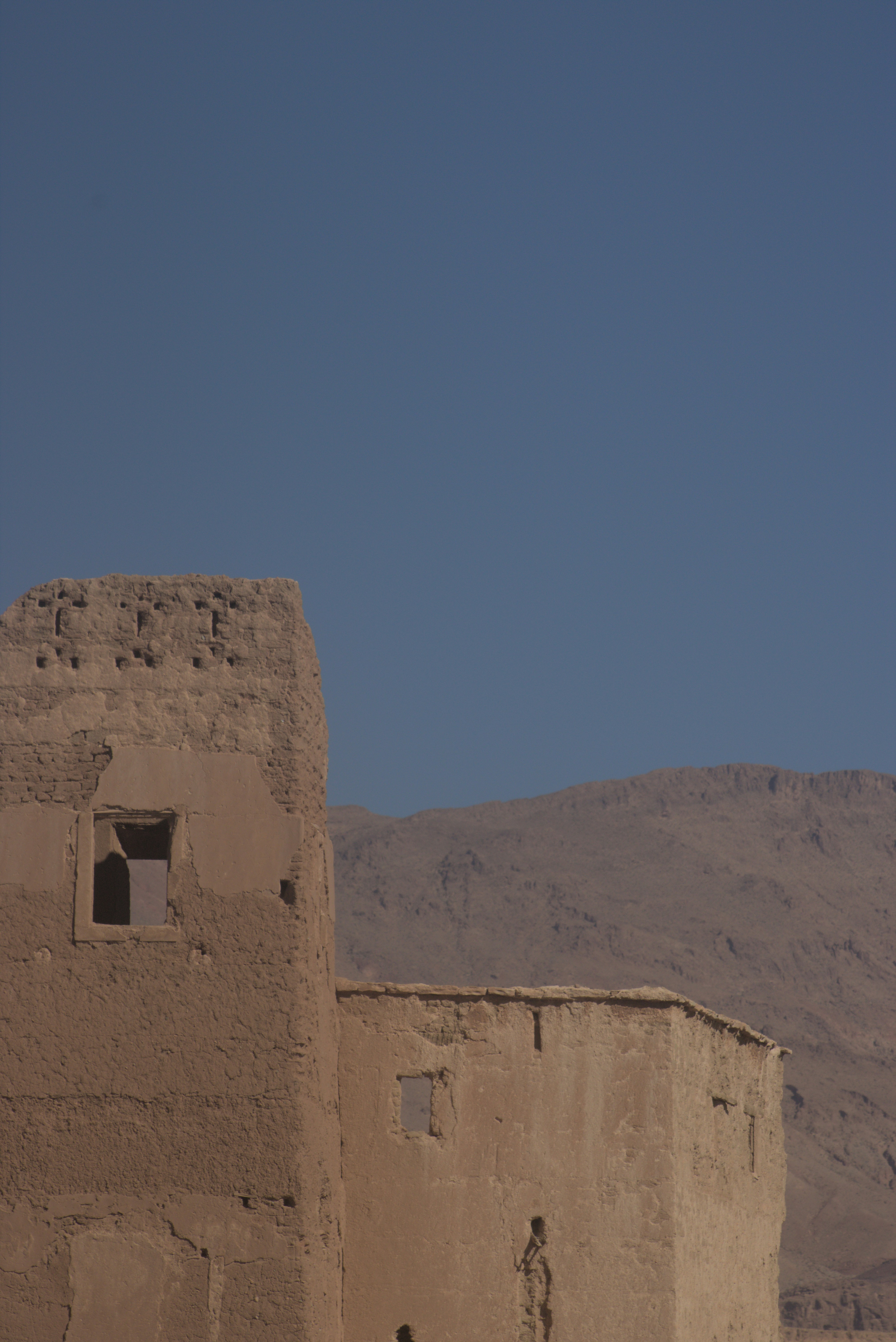 a stone building with a hill in the background