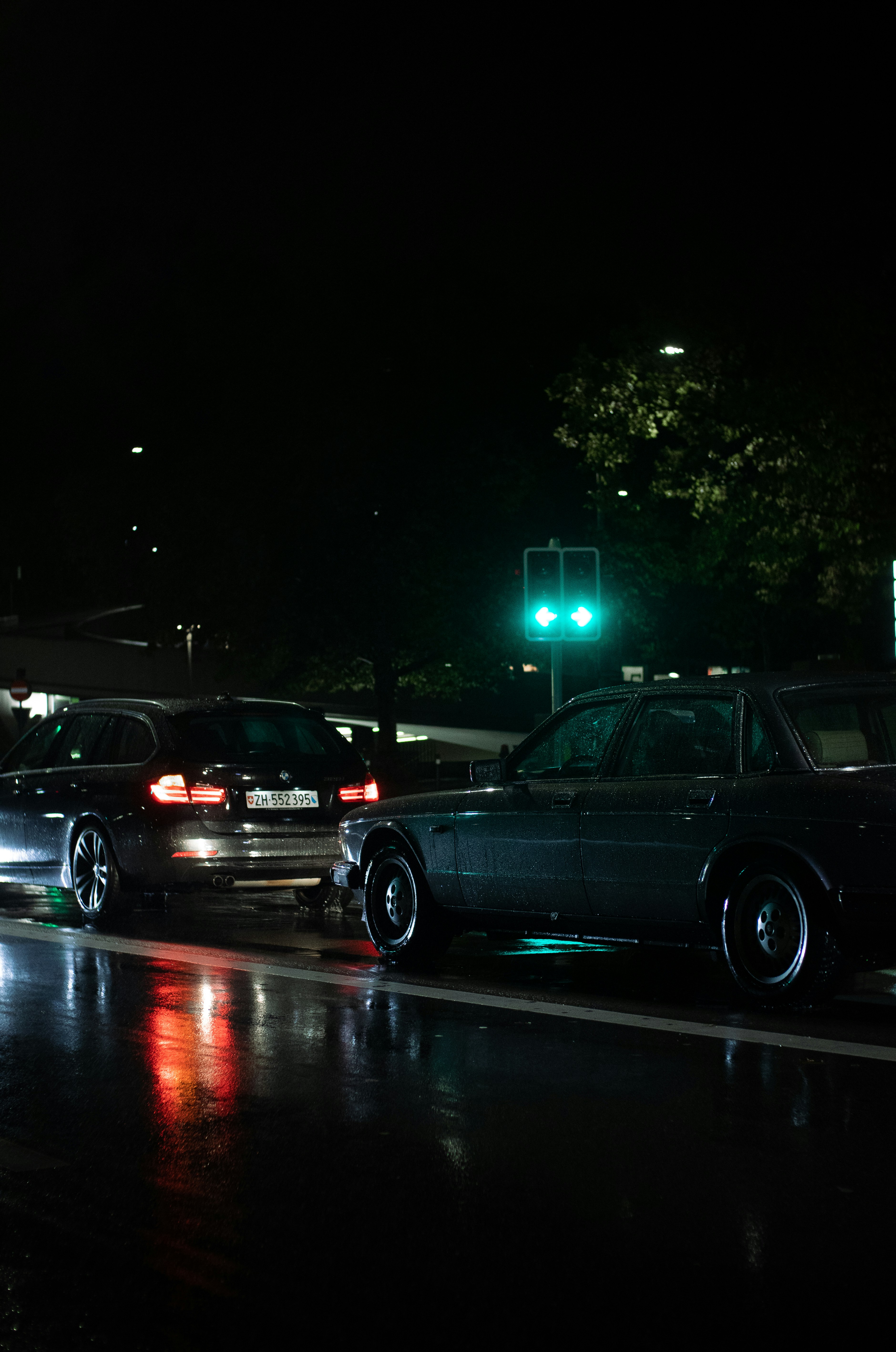 cars parked on the side of a road at night