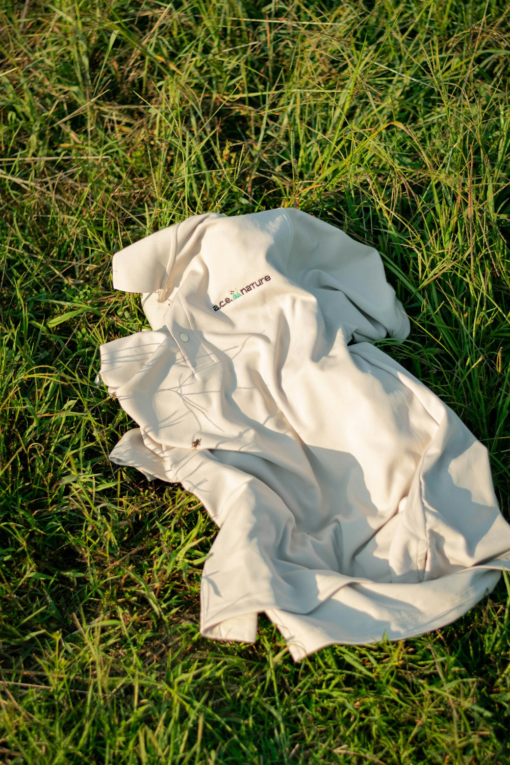 un morceau de tissu blanc posé sur un champ vert