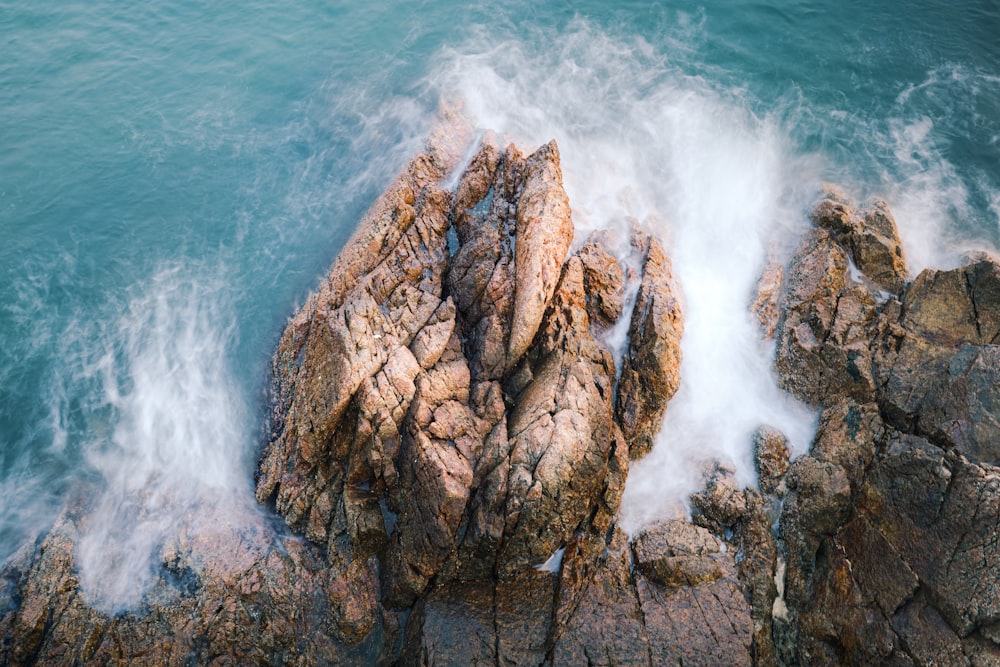 a rocky cliff with waves crashing against it