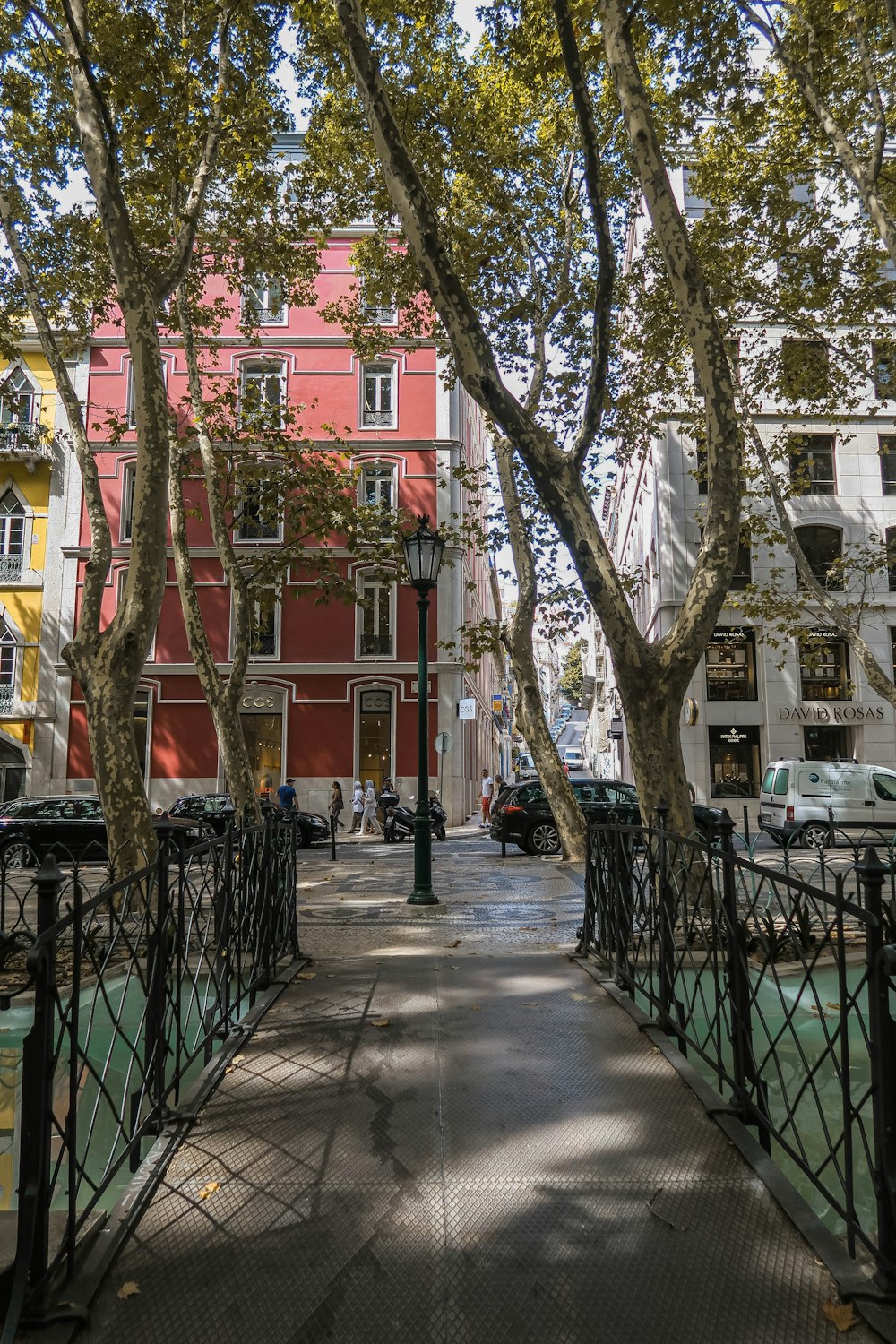 a sidewalk with trees and buildings on the side