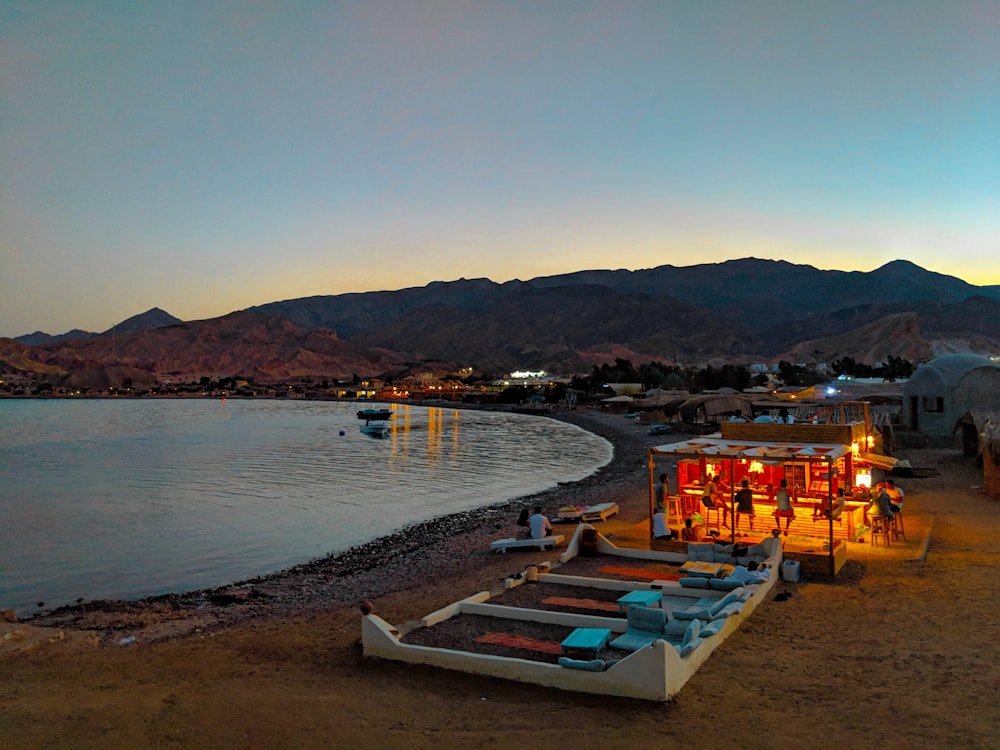 a beach with boats and a body of water with mountains in the background