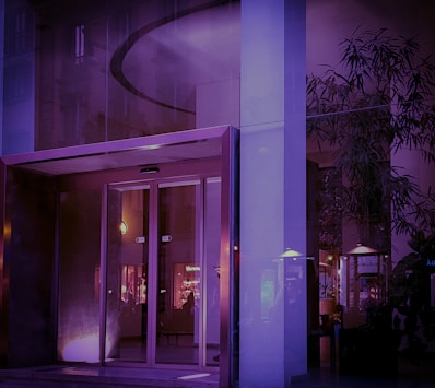 Modern condo building entrance with glass doors and stylish exterior lighting.