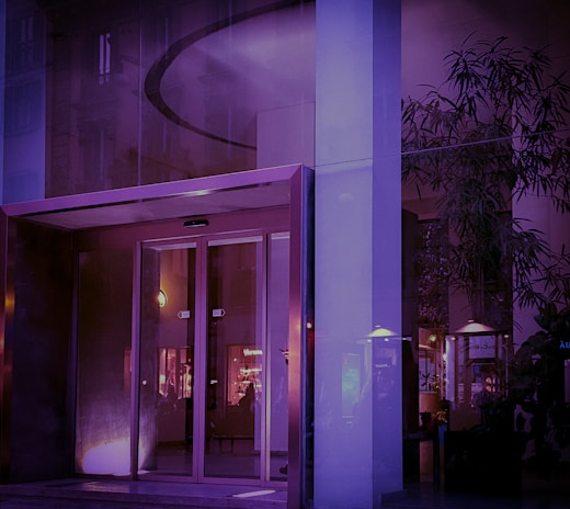 Elegant corporate building entrance with glass doors and subtle blue accents reflecting professionalism.