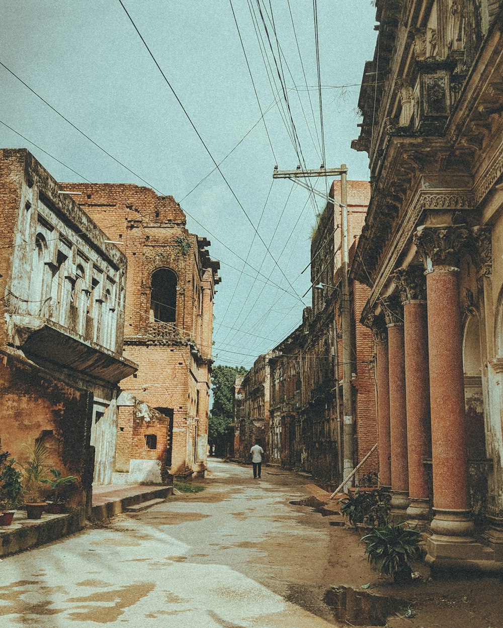 a person walking down a street between buildings