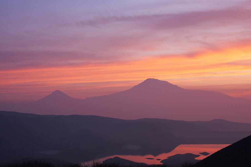 Une chaîne de montagnes avec un coucher de soleil