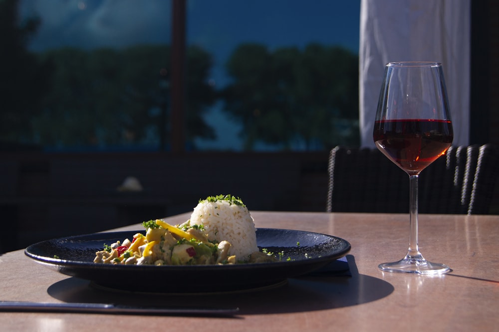 a plate of food and a glass of wine on a table