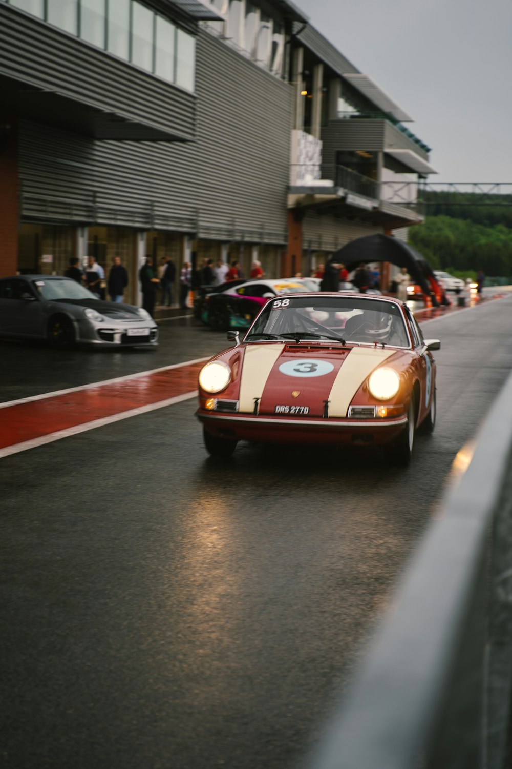 a red race car on a wet road