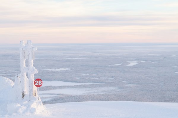 A frozen trail marker on the snowy fell top — Ylläs, Finland