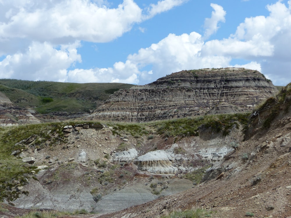 a rocky mountain with grass and rocks