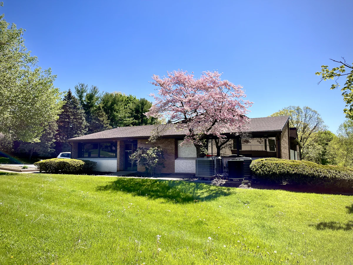 Single-story brick ranch home with large lawn