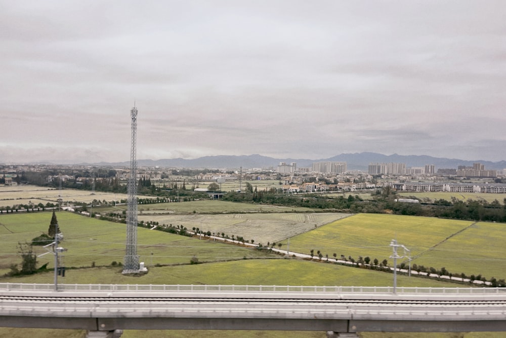 a large green field with a tower in the distance