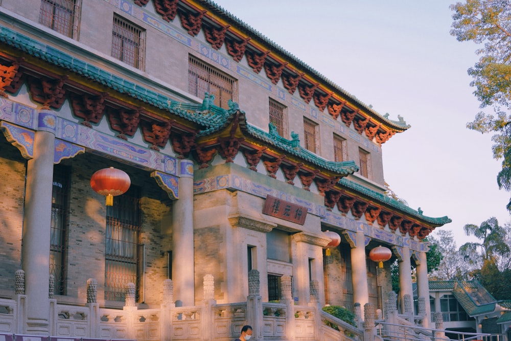 a building with columns and a large red ball in front