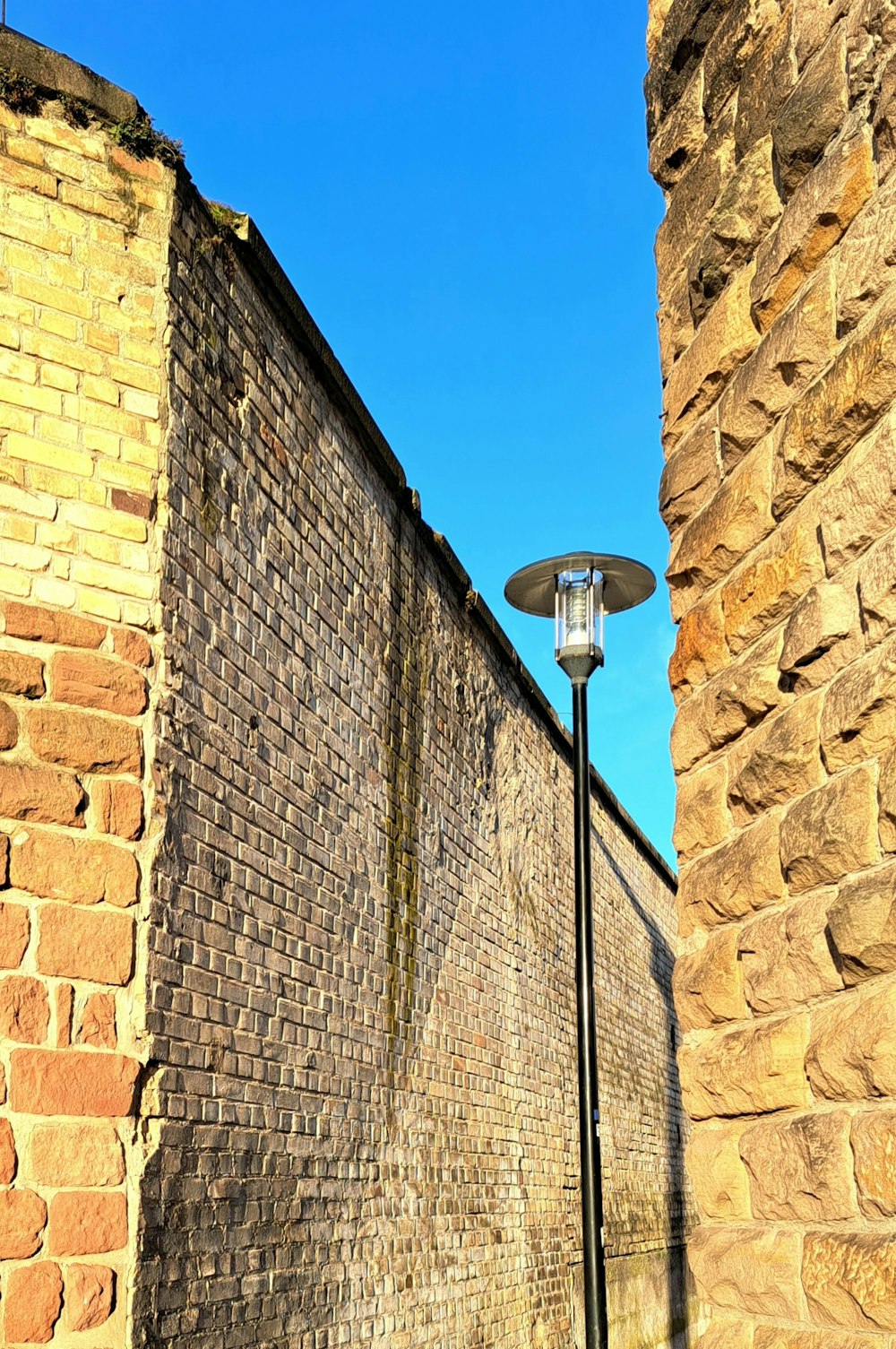 a brick wall with a lamp post