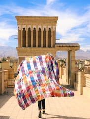 a person walking in front of a building with a colorful design