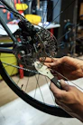 A mechanic adjusting the brakes on an electric bike in a bright, organized workshop.