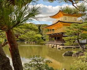 A serene temple entrance surrounded by lush greenery under a clear blue sky.