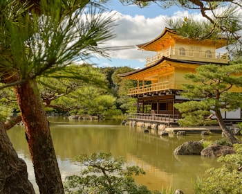 A serene temple entrance surrounded by lush greenery under a clear blue sky.